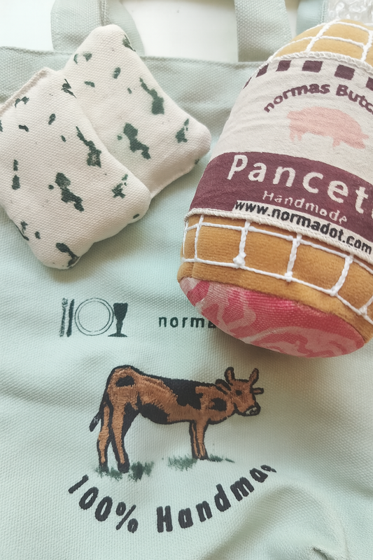 Two fabric products with branding and a cow illustration on a light background