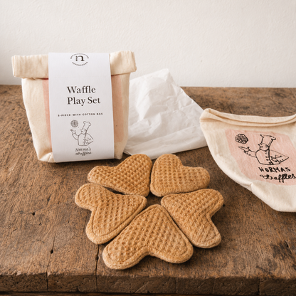 Heart-shaped waffle toys with packaging on a wooden surface