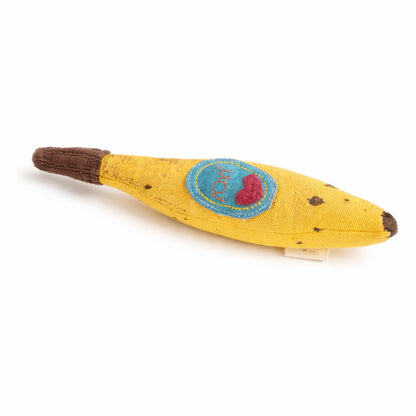 Yellow toy resembling a fabric banana with a blue patch and red heart on a white background
