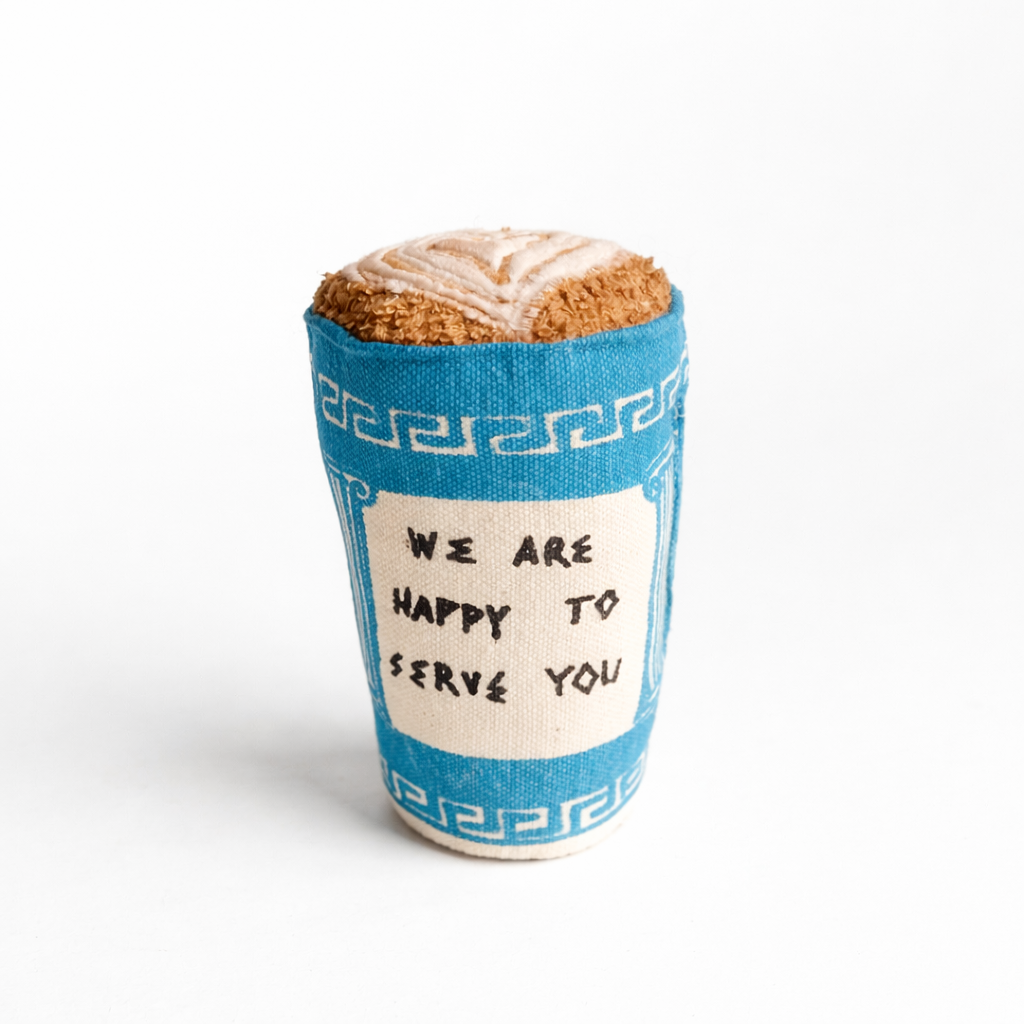 Handmade fabric Greek coffee cup  with blue-and-white print and soft latte art top on a clean white studio background.