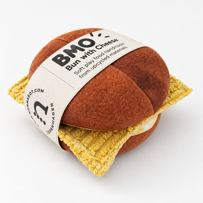 Handmade Danish BMO bun with cheese play food made from sweatshirt fabric and cotton, wrapped in a normadot paper band on a white studio background