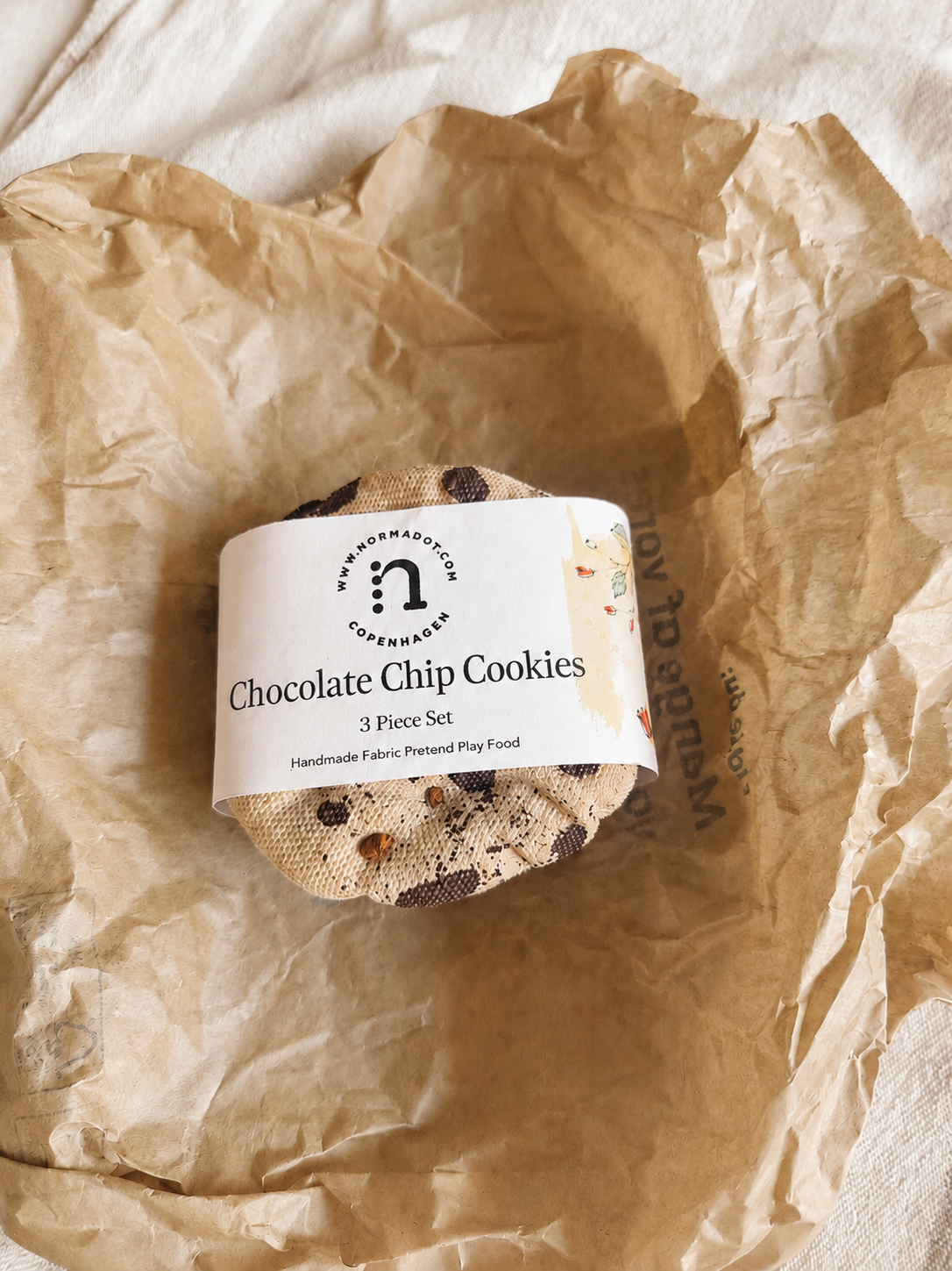 Set of fabric play food chocolate chip cookies in packaging with a label on crumpled brown paper.