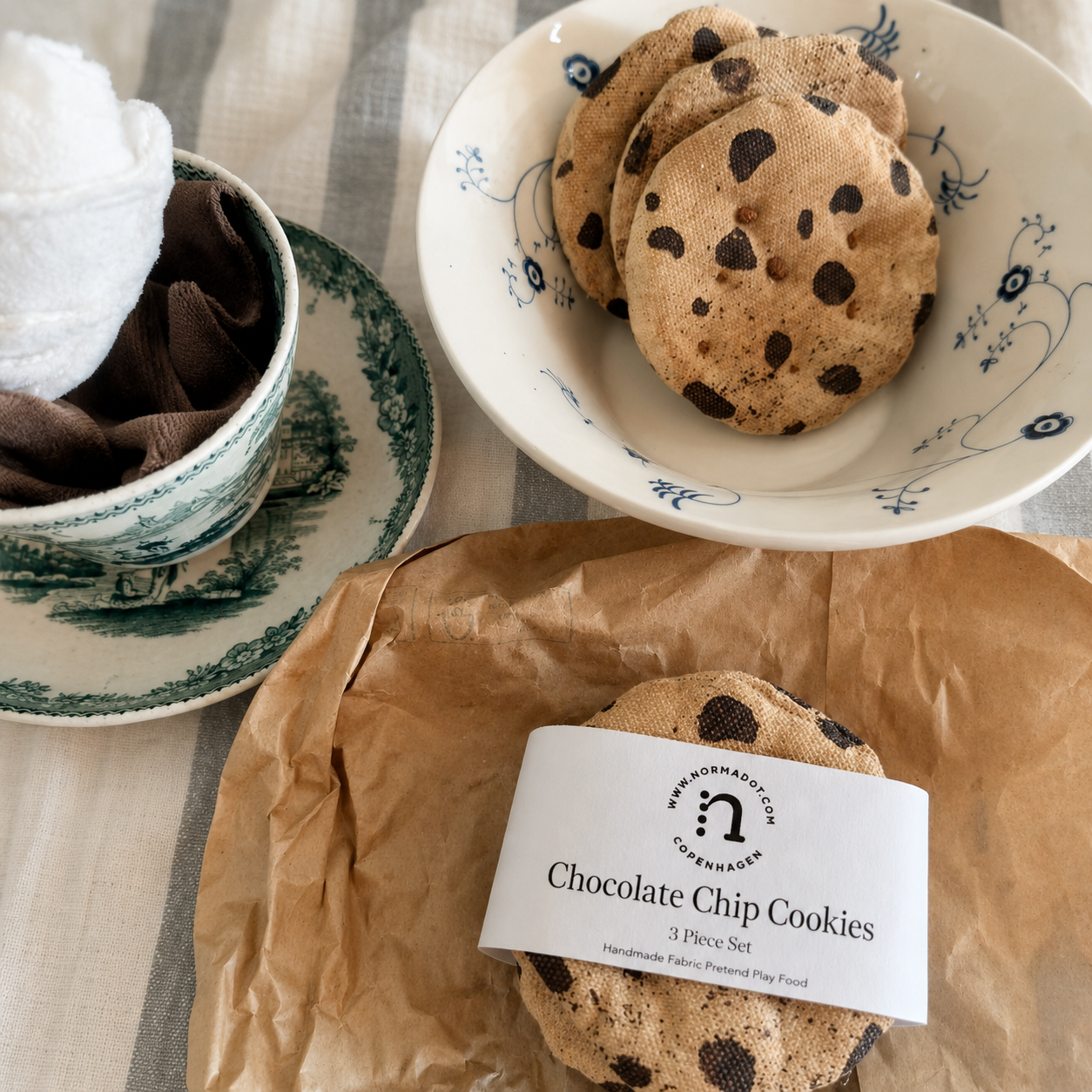 Handmade fabric chocolate chip cookies shown with their normadot packaging in a pretend tea party setting.