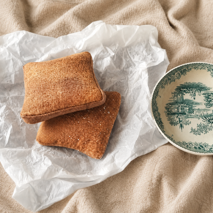 Two handmade textile French toast play food pieces beside a vintage plate