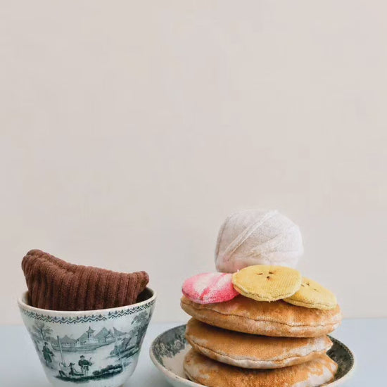 Handmade pancake play food set made from soft fabric, with textile pancakes, fruit toppings and whipped cream for pretend play kitchens.