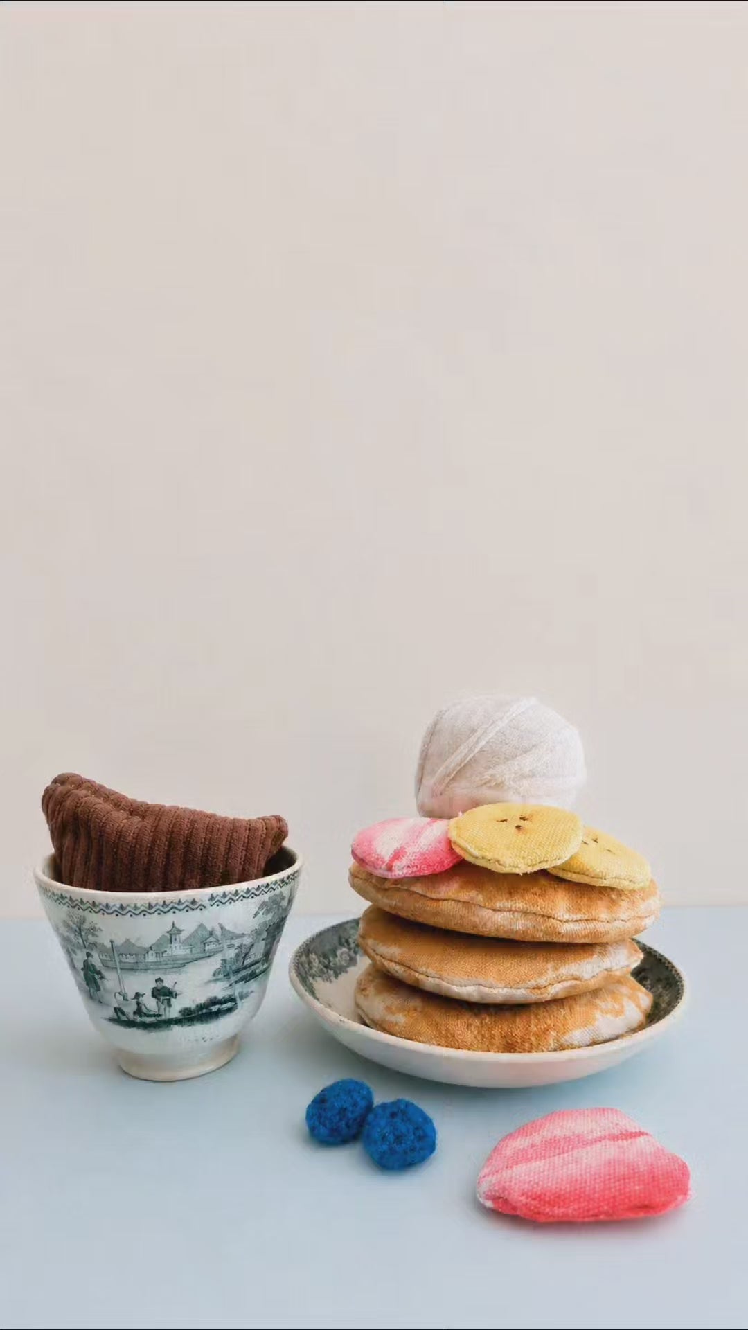 Handmade pancake play food set made from soft fabric, with textile pancakes, fruit toppings and whipped cream for pretend play kitchens.
