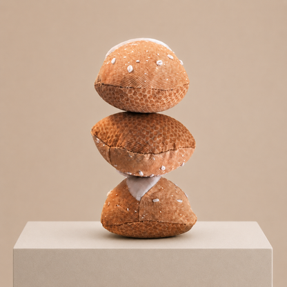 Three handmade fabric bread rolls stacked on a neutral display pedestal, handmade in Denmark by normadot